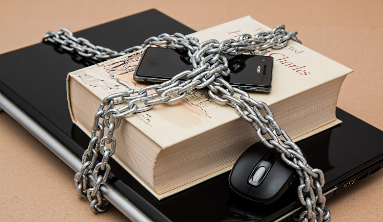 Chains locked around books, laptop, and cell phone